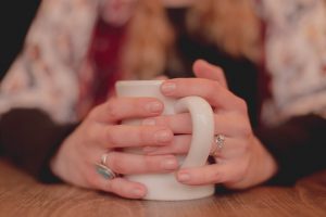 Close up of hands holding a hot drink in a mug